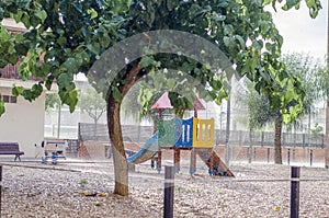 It is raining in a children`s playground, rain drops falling