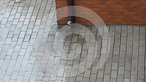 It is raining heavily, water flowing onto a gray tiles