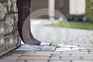 Rainwater flows out of the drainpipe during the melting of snow