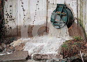 Rainwater outflows through flood drainage system, Water runoff from road spillway to sewage