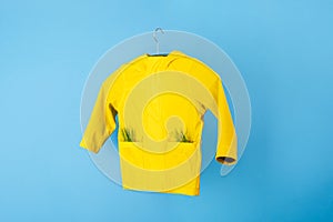 Rainwear recycling. used outerwear. Ecological and sustainable lifestyles. mock up yellow raincoat on a blue background