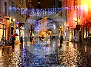 Rainy Autumn Travel to Europe    in the City Christmas Tallinn Old town street night  light people walking with umbrellas rain dro