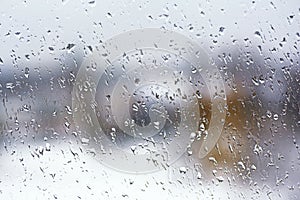 Rainy city background. Raindrops on window glass. Wet home window with raindrops