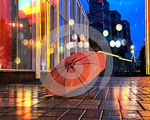 Rainy city  in city pink umbrella on asphalt night blurred light urban lifestyle