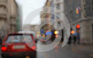 Rainy city scenery through wet windscreen