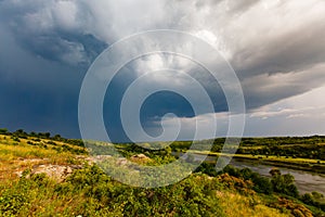 Rainy clouds floating towards river. Storm starting on sunny day