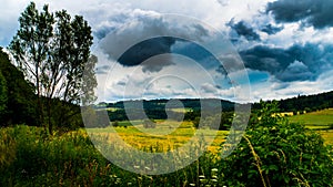 Rainy clouds over a mountainous field photo