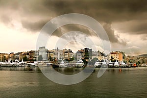 Rainy day with cloudscape.Luxury Yachts in a row at marina Zeas