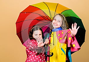 Rainy day fun. Happy walk under umbrella. Kids girls happy friends under umbrella. Rainy weather with proper garments