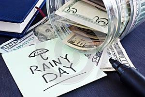 Rainy day fund savings. Jar with dollar bills. photo