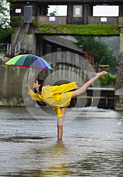 Rainy day. Funny excited woman in raincoat hold umbrella with rainy water drops. Girl in rain with umbrella in rainy