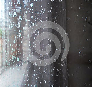 Raindrops on a window pane. Drops of water on a metal surface, on a window pane, Window in a house in rainy time photo