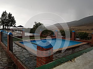 Rainy day at the swimming pool of a small spain village.