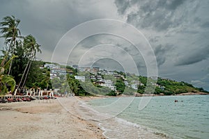 Rainy day at the tropical beach with palm trees. Thailand.