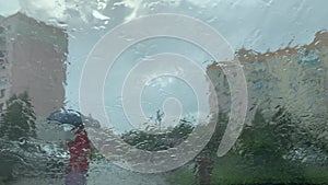 Rainy day through the windshield of a car on the background of city