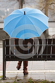 Rainy day woman holding blue umbrella