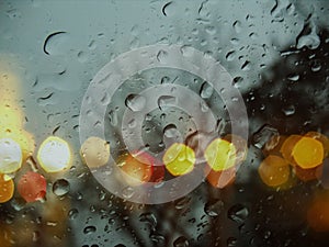 Rainy drops water on window evening blurred blue yellow light reflection rain template textured background weather