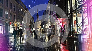 Rainy evening in city autumn season people walk  under umbrella on wet pavement street lifestyle urban rainy drops  reflection on