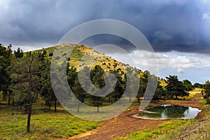 Rainy heavy clouds above green mountain