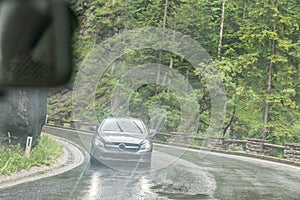 Rainy road surface and raindrops on a car windshield