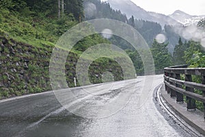 Rainy road surface and raindrops on a car windshield