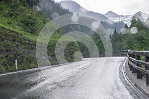 Rainy road surface and raindrops on a car windshield