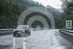 Rainy road surface and raindrops on a car windshield