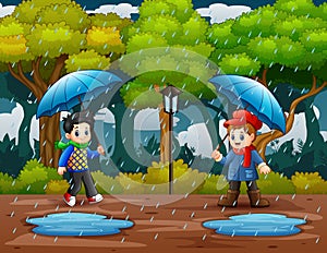 Rainy season with two boys carrying umbrella in the park