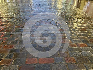 Rainy sidewalk lit by city evening light reflection   on old pavement  rainy evening city light    blurring bokeh eff