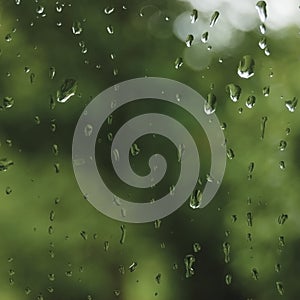Rainy summer day, raindrops on wet window glass, bright abstract rain water background pattern detail, macro closeup, detailed