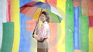 Rainy weather girl. Rain woman with rainbow umbrella. Autumn mood. Abstract background.