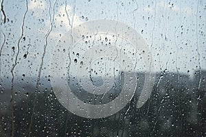 Rainy weather landcsape view through a window with rain drops on the glass