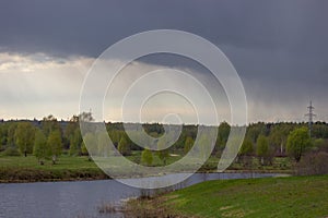 rainy weather landscape, rain over the river in the distance.