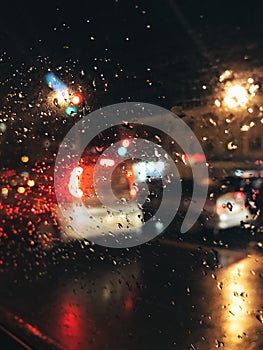 rainy weather on a night city street cars in the rain and traffic lights