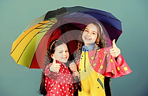 Rainy weather with proper garments. Happy childhood. Bright umbrella. It is easier to be happy together. Be rainbow in