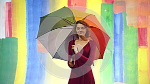 Rainy weather. Rain woman with rainbow umbrella. Autumn mood. Abstract background.