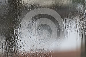 Rainy weather, raindrops on the glass of window, water drips wet. Texture, background