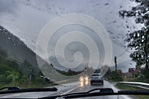 Rainy weather traffic in the countryside as seen through wet car window