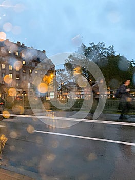 Rainy windshield of a car at the unrecognizable pedestrians