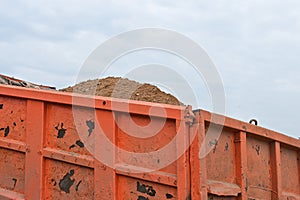 Raised bucket of a truck, unloading sand