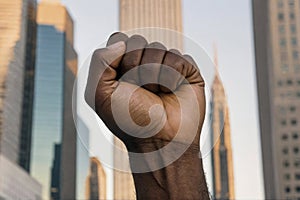 Raised clenched black male fist symbolizing protest against racism, discrimination fight for civil rights, equality