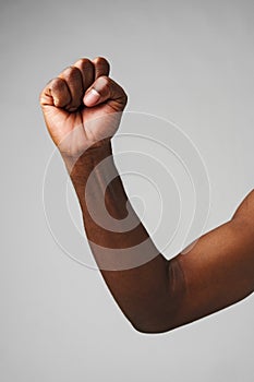 Raised Fist of Determination and Strength Against a Gray Background