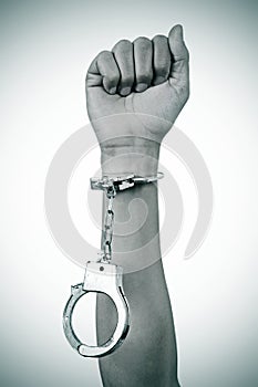 Raised fist of a man with a handcuff in his wrist