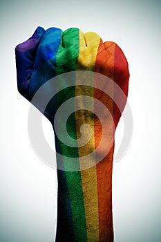 Raised fist patterned with the rainbow flag, symbolizing the fig