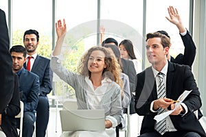 Raised hands and arms of large group of people in class room, audience voting in professional education surrounding