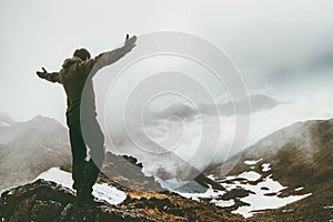 Raised hands Man on foggy mountain summit