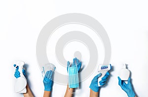 Raised hands in medical gloves holding masks, sanitizers, soap, non contact thermometer on white background. Banner. Copy space.