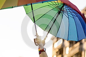 Raised hands with rainbow colored umbrellas