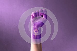 Raised purple fist of a woman for international women`s day and the feminist movement. March 8 for feminism, freedom photo