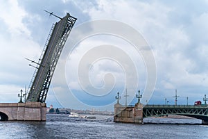 Raised span of movable single-leafed bascule Trinity bridge in Saint Petersburg, cloudy day, view from the side. Upward